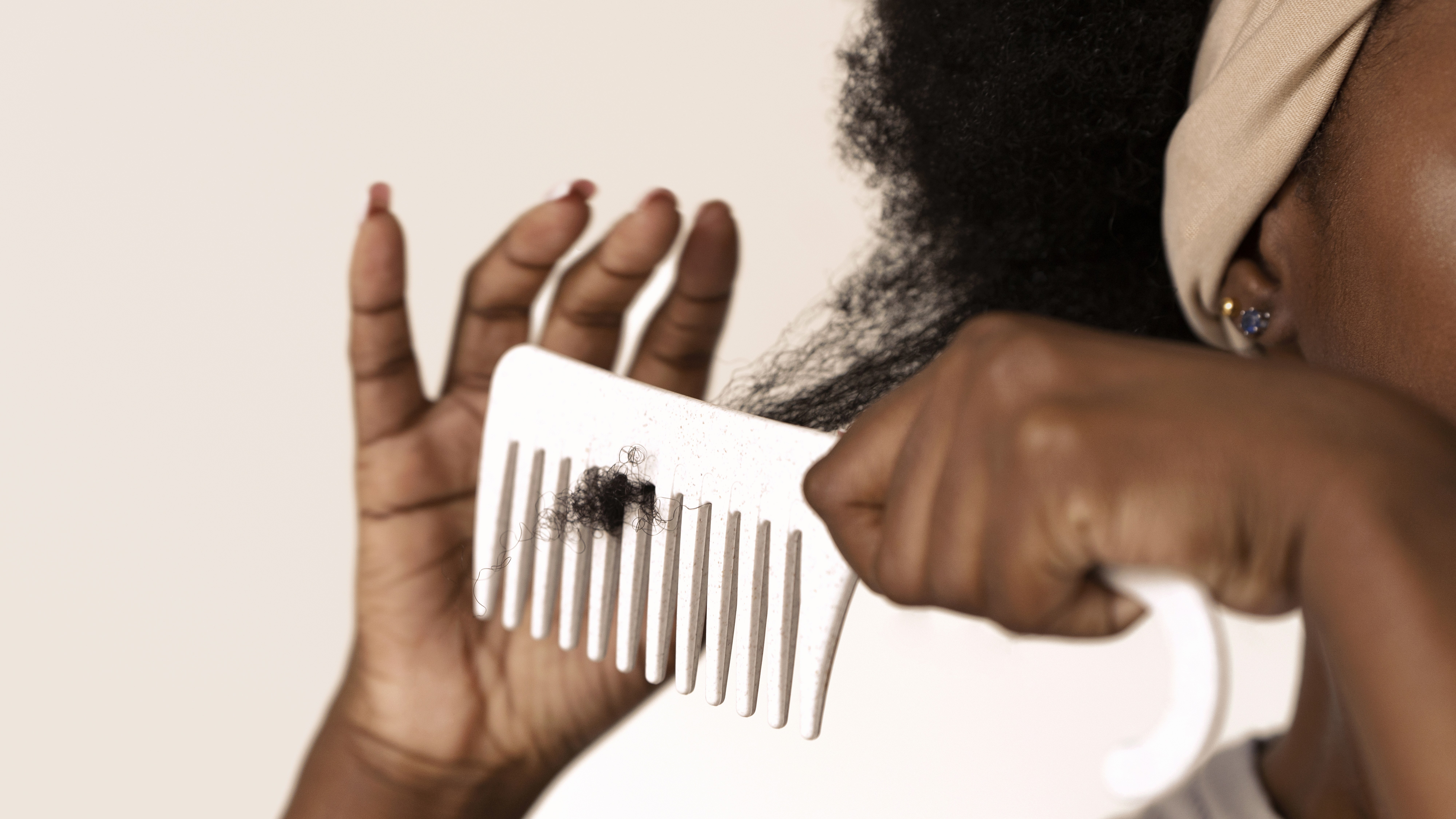 black woman using hair comb on afro