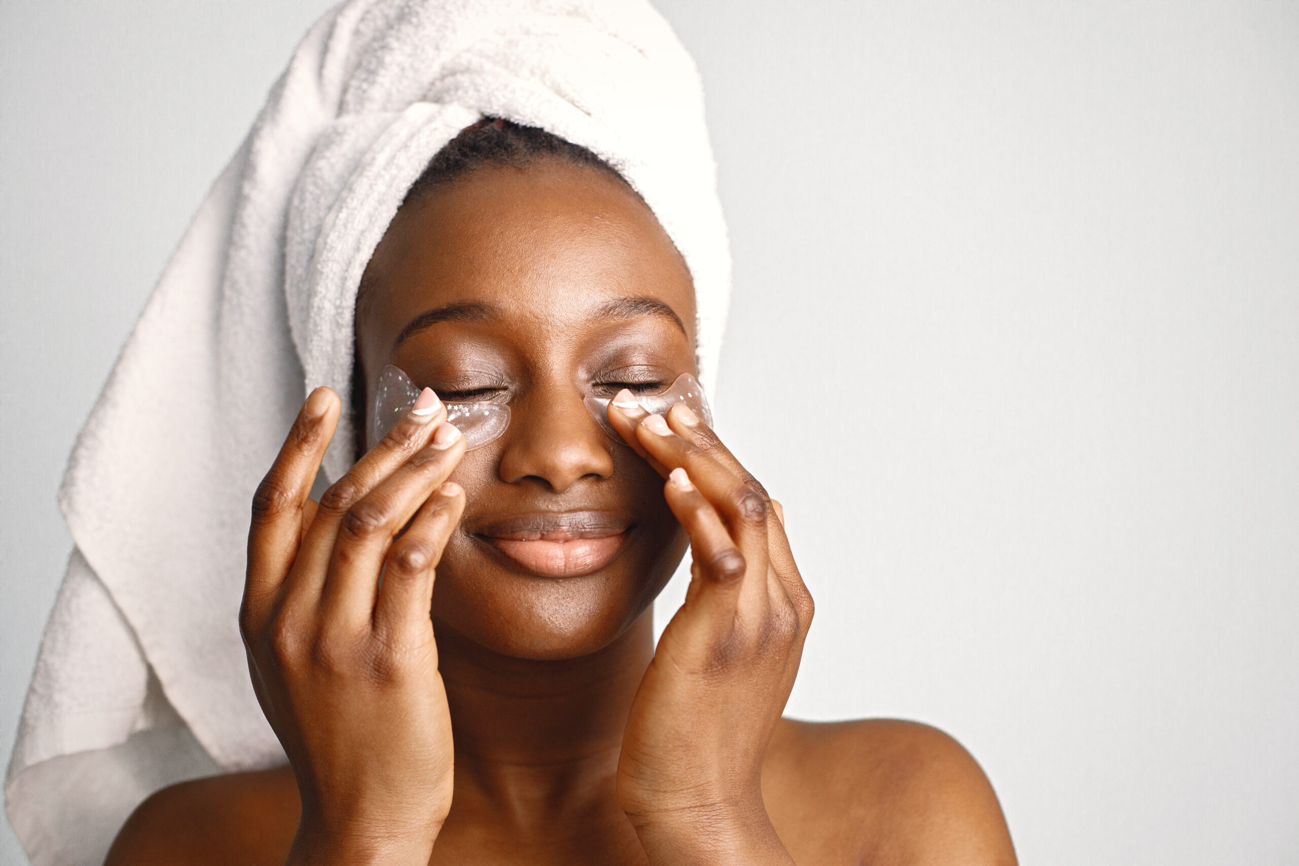Black girl taking care of her skin with a towel on her head